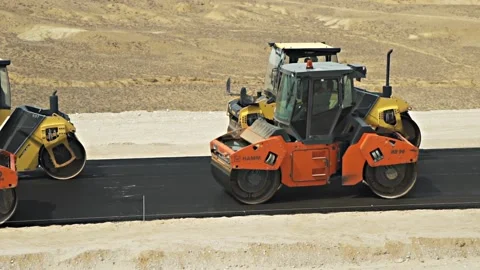 Road rollers drive on black asphalt gravel aligning highway Stock Footage 134460708