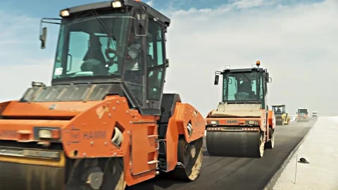 Road rollers drive on raw asphalt gravel of new highway Stock Footage 134460684