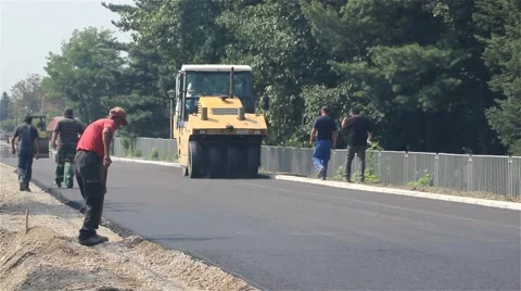 Road rollers flattens asphalt. Steamrollers smoothing asphalt. Workers. Shovels. Stock Footage 41740874