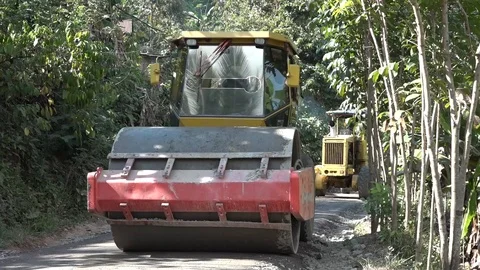 A road rolling machine flattens road to Hobbit cave on Flores Stock Footage 87438690