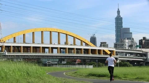 Road runner caucasian man running on road with view of building Taipei 101 -Dan Stock Footage 63658641