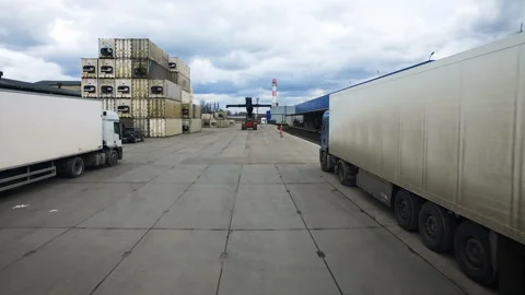 The road running through the warehouse complex. Worker and excavator go through Stock Footage 98788349