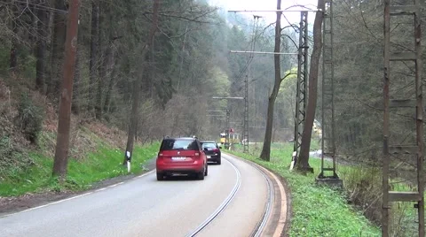 Road sharing scene between oncoming tram train and motor cars Stock Footage 64755232