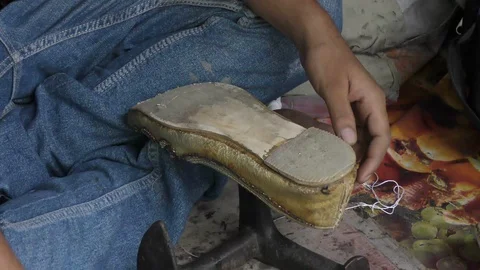 A road side cobbler uses hammer and nails to fix the shoe and repair Video stock 112855268