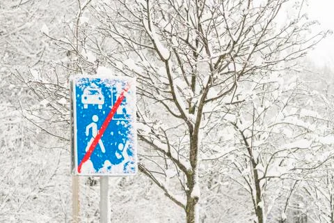 The road sign and trees are covered with snow. Winter, cold. Stock Photos