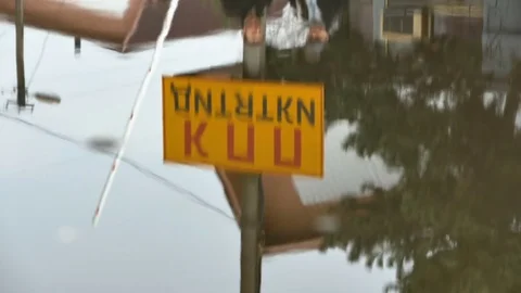 The road sign of the bus stop is reflected in a puddle of water Stock Footage 75028939