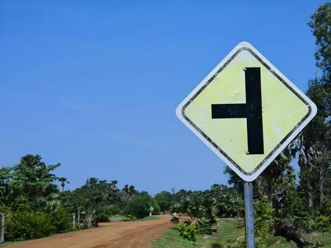 Road Sign Indicating Sharp Turn on Dirt Path in Rural Landscape Stock Photos