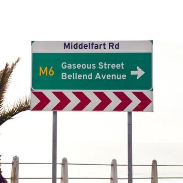 Road sign, intersection and direction in city with arrow for grammar, mistake or Stock Photos