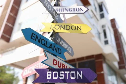 Road sign with pointers of different cities and countries Stock Photos