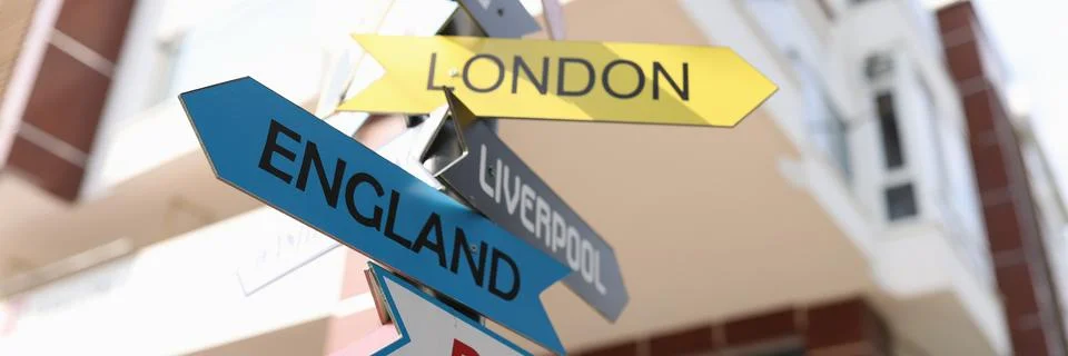 Road sign with pointers of different cities and countries Stock Photos