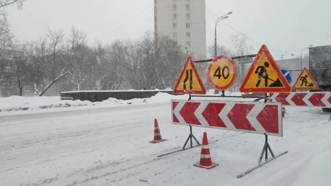 Road sign repair work, speed limit and detour on a snowy urban highway. The road Stockbeeldmateriaal 260831748