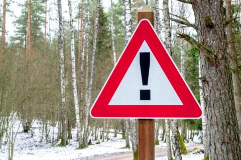 Road sign triangular shape with exclamation mark. Red attention traffic sign. Stock Photos