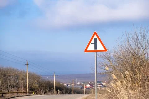 Road sign warning of an intersection with a minor road Stock Photos