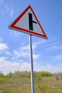 Road sign warning turn from main road blue sky background. Stock Photos