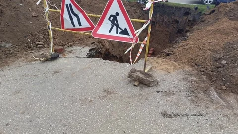 Road signs warning of construction work and a ban on travel. The dug-out pit is Stock Footage 317669747