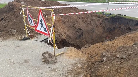 Road signs warning of construction work and a ban on travel. The dug-out pit is Stock Footage 317669751