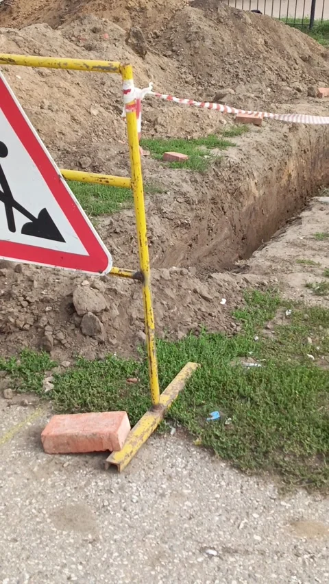 Road signs warning of construction work and a ban on travel. The dug-out pit is Stock Footage 317669875