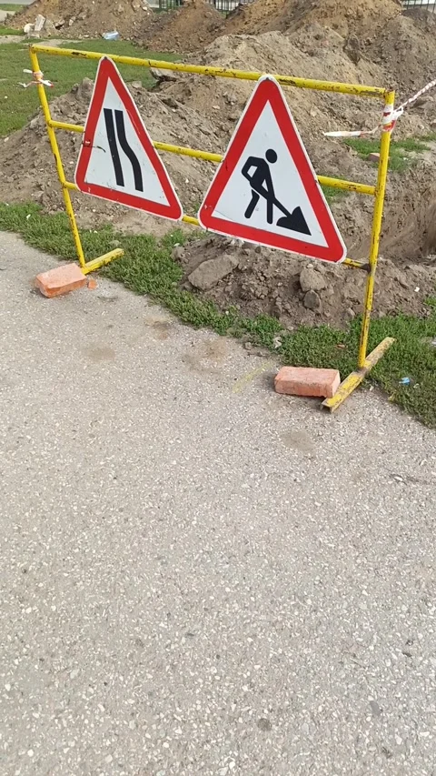 Road signs warning of construction work and a ban on travel. The dug-out pit is Stock Footage 317669885