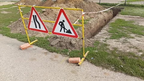 Road signs warning of construction work and a ban on travel. The dug-out pit is Stock Footage 317669904