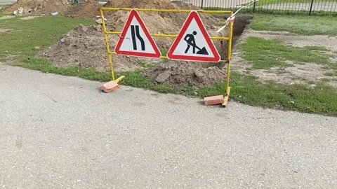 Road signs warning of construction work and a ban on travel. The dug-out pit is Stock Footage 317669910