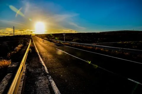 A road with a sun setting in the background Foto stock