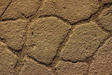Road surface made of old asphalt with cracks. Stone texture with warm light.  Foto stock