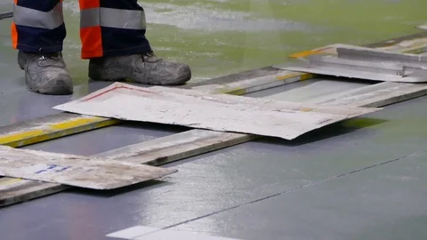 Road surface marking in underground garage by workers in orange Stock Footage 94599068