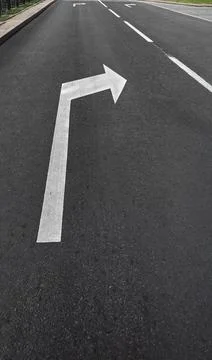 Road surface with white arrow marking indicating right turn direction Stock Photos