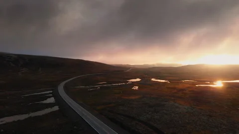 Road surrounded by hills and fields at bright sunset Stock Footage 255732214