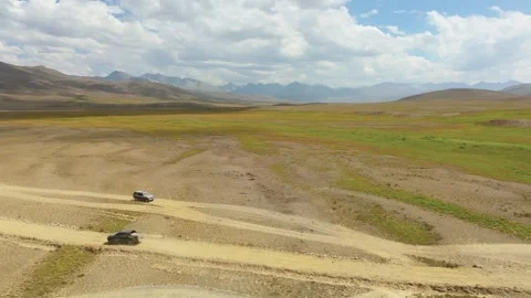 Off road SUVs passing each other on a dusty trail in the Deosai Plains Stock Footage 345622403