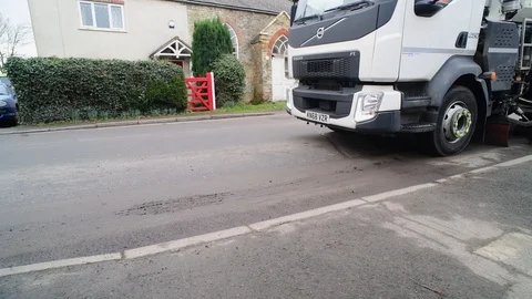 Road sweeping lorry cleaning roadside gutters in street yorkshire uk Stock Footage 123833899