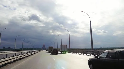 Road through the bridge with cloudy sky and moving cars in slowmotion. 1920x1080 Stock Footage 66564068