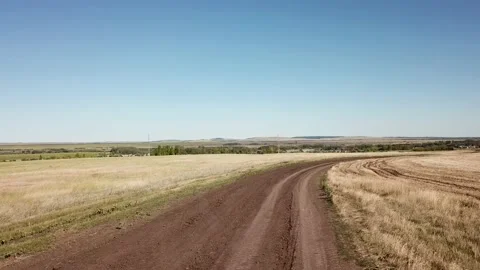 The road through the fields leading to a small village. Video stock 137778398