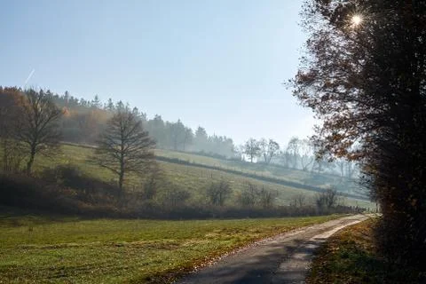 Road through the fields, midday and haze Stock Photos