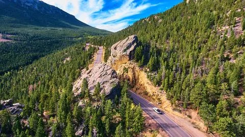 Road through large boulder in the mountains of pine trees Foto stock
