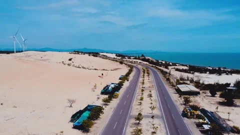 A road through the sandy desert, with the sea visible in the distance. Stock Footage 303461041