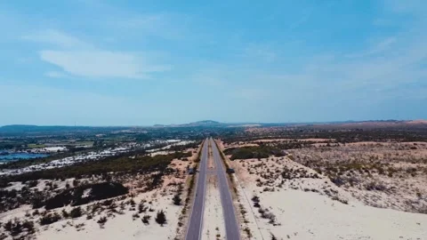 A road through the sandy desert, with the sea visible in the distance. Stock Footage 303461052