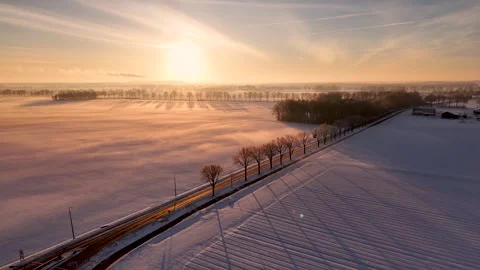 Road Through Snowy Fields Illuminated, Scenic Route Bordered By Trees Through Stock Footage 327052040