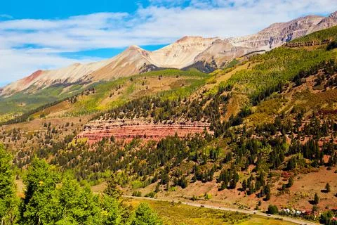 Road through valley of mountain range near fall Stock Photos