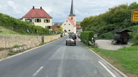 Road through the vineyards. Field workers ride on a tractor. Stock Footage 221648542