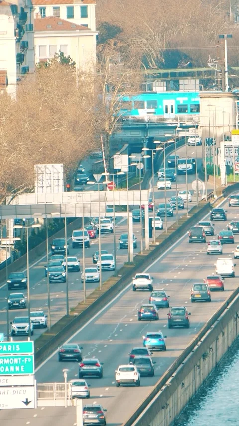 Road traffic on the busy Rhone River embankment and suburban trains in Lyon Stock Footage 323803206