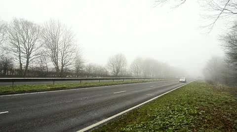 Road traffic on a foggy morning Stock Footage