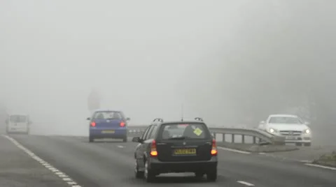 Road traffic on a foggy morning Stock Footage