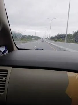 Road trip on a cloudy day perspective from the inside of a car Stock Photos