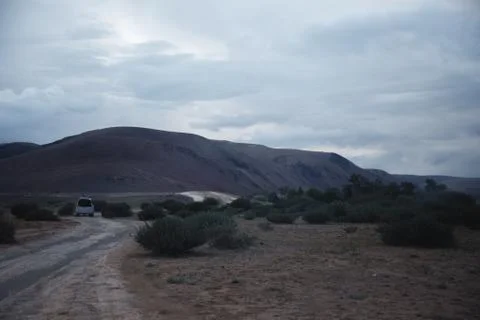 Off-road trip, dramatic sky in the background. Misty road in the mountains Stock Photos