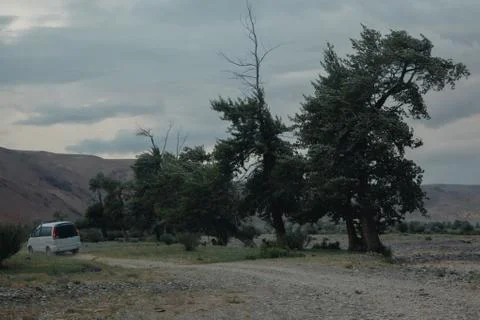 Off-road trip, dramatic sky in the background. Misty road in the mountains Stock Photos