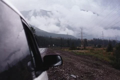 Off-road trip, dramatic sky in the background. Misty road in the mountains Stock Photos