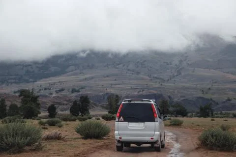 Off-road trip, dramatic sky in the background. Misty road in the mountains Stock Photos