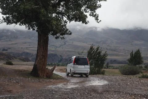Off-road trip, dramatic sky in the background. Misty road in the mountains Stock Photos