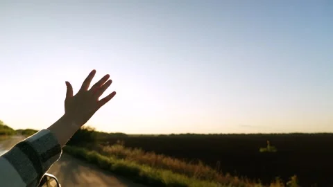 Road trip female hand from window of driving car at sunset sunrise rural summer Stock Footage 303073169